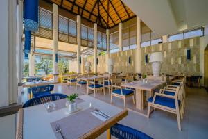 a dining room with tables and chairs and windows at Bhu Nga Thani Resort & Villas Railay in Railay Beach