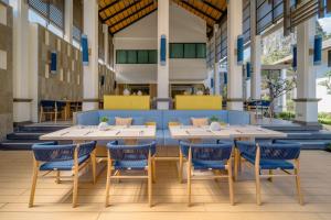 a dining room with two tables and blue chairs at Bhu Nga Thani Resort & Villas Railay in Railay Beach