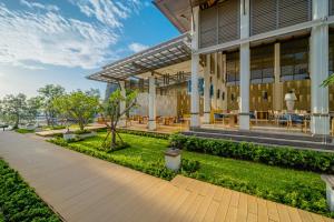 an exterior view of a building with tables and chairs at Bhu Nga Thani Resort & Villas Railay in Railay Beach