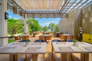 a restaurant with tables and chairs and a large window at Bhu Nga Thani Resort & Villas Railay in Railay Beach