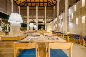 a dining room with wooden tables and chairs at Bhu Nga Thani Resort & Villas Railay in Railay Beach