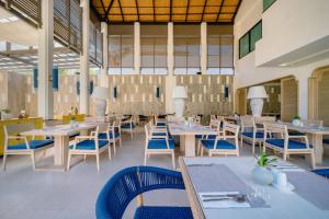 a restaurant with white tables and blue chairs at Bhu Nga Thani Resort & Villas Railay in Railay Beach