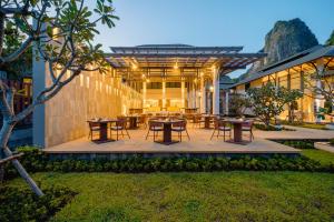 a patio with tables and chairs in a yard at Bhu Nga Thani Resort & Villas Railay in Railay Beach