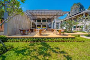 a patio with tables and chairs in a yard at Bhu Nga Thani Resort & Villas Railay in Railay Beach