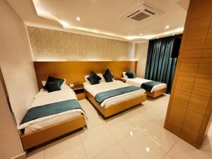 um quarto de hotel com duas camas e uma janela em King Hotel Karbala em Karbala