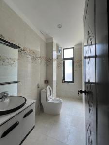 峴港的住宿－Qi Villa My Khe Beach，白色的浴室设有卫生间和水槽。