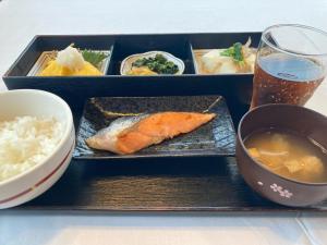 a tray with a plate of food and a glass of beer at Hotel Alpha-One Tsuyama in Tuyama