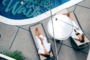 two women laying in chairs next to a swimming pool at 8HOTEL Chigasaki in Chigasaki