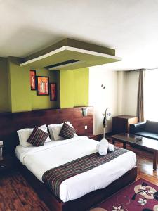 1 dormitorio con 1 cama grande y 1 sofá en Hotel Le Primula, en Gangtok