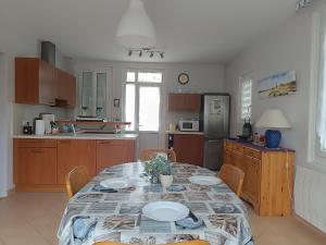 una cocina con mesa y sillas y una cocina con mesa y sillón. en Maison familiale 5 pers à St Brevin proche plage - FR-1-364-90, en Saint-Brevin-les-Pins