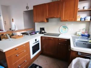 cocina con armarios de madera, fregadero y fogones en Maison familiale 5 pers à St Brevin proche plage - FR-1-364-90, en Saint-Brevin-les-Pins