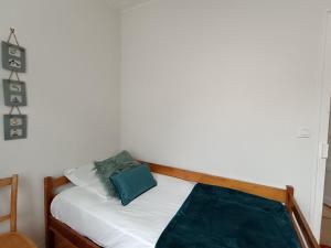 Una cama pequeña con una almohada azul. en Maison familiale 5 pers à St Brevin proche plage - FR-1-364-90, en Saint-Brevin-les-Pins