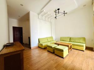 峴港的住宿－Qi Villa My Khe Beach，客厅配有两张绿色沙发和一张桌子