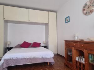 um quarto com uma cama com almofadas roxas e um relógio em Studio Collioure, 1 pièce, 3 personnes - FR-1-309-234 em Collioure