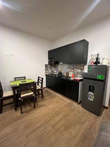 una camera con cucina completa di tavolo e frigorifero di Cómodo céntrico y acogedor apartamento a Tarija