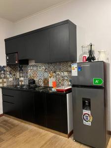 uma cozinha com armários pretos e um frigorífico em Cómodo céntrico y acogedor apartamento em Tarija