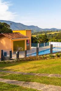 a house with a fence in front of a yard at Sua casa na Serra da Mantiqueira. 1h de SP in Extrema