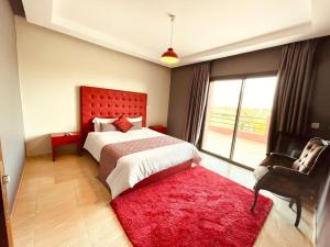 a bedroom with a bed with a red headboard and a red rug at Villa Dar El Hna in Marrakesh