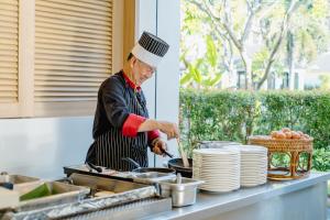 a chef preparing food in a kitchen at Bhu Nga Thani Resort & Villas Railay in Railay Beach
