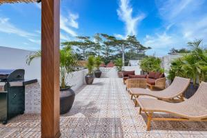 a patio with chairs and tables on a patio at Elena Villa by Betterplace in Tanah Lot