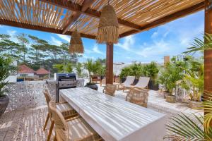 an outdoor patio with a white table and chairs at Elena Villa by Hombali in Tanah Lot