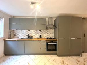 a kitchen with gray cabinets and a stove top oven at Central London Zone 1 apartment in London