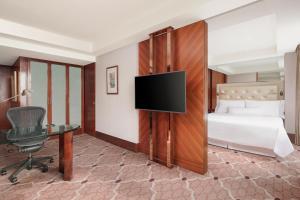 a hotel room with a bed and a flat screen tv at The Westin Bund Center, Shanghai in Shanghai