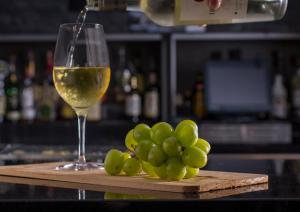 a glass of white wine next to a bunch of grapes at Holiday Inn Carlsbad/San Diego, an IHG Hotel in Carlsbad