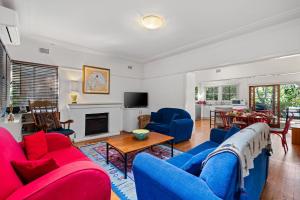 a living room with blue and red furniture and a fireplace at King Parrot in Pearl Beach