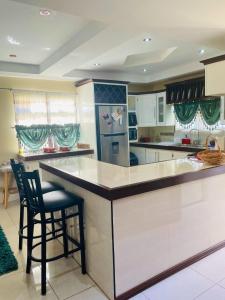 a kitchen with a counter and a bar with a chair at Travelholics Getaways in Piarco