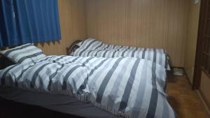 a bedroom with two beds with striped sheets at Kami House Annex in Osaka