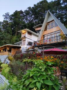 une maison avec un balcon et un jardin fleuri dans l'établissement Zangmo Lee Baam Rezay gangtok Sikkim, à Gangtok
