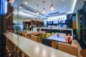 un restaurante con mesas y sillas y un bar en Yizhi Hotel - Guangzhou Zhujiang New City Huashi Metro Station en Guangzhou