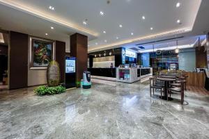 un restaurante con sillas y mesas en el vestíbulo en Yizhi Hotel - Guangzhou Zhujiang New City Huashi Metro Station en Guangzhou