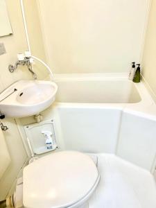 Baño blanco con aseo y lavamanos en Shibuya Honmachi Hana House, en Tokio
