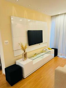 sala de estar con TV de pantalla plana en la pared en Brisa Mar en Vila Velha