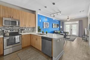 a kitchen with wooden cabinets and a blue wall at City Living in Downtown Raleigh Luxury Apt 1 in Raleigh