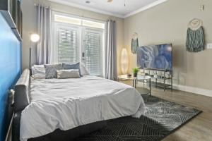 Un dormitorio con una cama grande y una ventana en City Living in Downtown Raleigh Luxury Apt 1, en Raleigh
