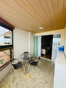Zimmer mit einem Glastisch und 2 Stühlen in der Unterkunft Brisa Mar in Vila Velha