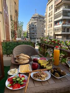 einen Tisch mit Tellern aus Essen auf einem Balkon in der Unterkunft Space Hostel in Kairo