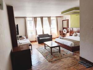 甘托克的住宿－Hotel Le Primula，酒店客房设有两张床、一张沙发和一张桌子。