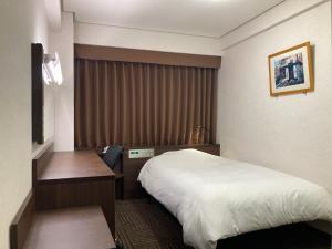 Habitación de hotel con cama y escritorio en Hotel Alpha-One Ogori, en Yamaguchi