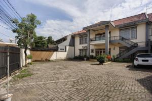 ein Haus mit einem Parkplatz davor in der Unterkunft RedDoorz syariah near AEON Mall Tanjung Barat in Jakarta