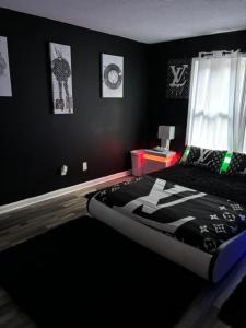 a bedroom with a bed and a black wall at Pressure Pad in College Park