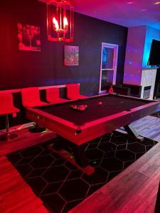 a ping pong table in a room with red lighting at Pressure Pad in College Park