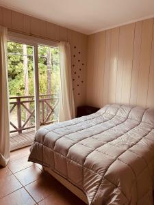 坦迪尔Duplex del Parque的一间卧室，里面有一张床和一扇大窗户。