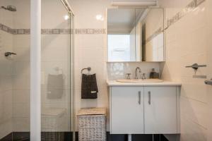 a bathroom with a sink and a shower at La Ronde One - Unit 1 - oceanstays in Yamba +23 photos