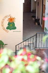 un cartel en una pared junto a las escaleras con flores en Hotel Cielo y Selva, San Cristobal de las Casas en San Cristóbal de Las Casas