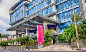 un edificio con una señal roja delante de él en Grand Tjokro Premiere Bandung en Bandung