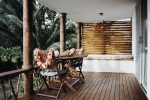 una terraza de madera con mesa y sillas. en Tai Marino - Beach Bungalows en Amuri